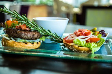 Beef Burger yemek fotoğraf çekimi, patates, patates, patates, salata, ekmek, şeffaf cam tabak, sığ alan derinliğinde fotoğraf seçici odak. Kahire 'deki Sheraton Oteli' nde çekildi.