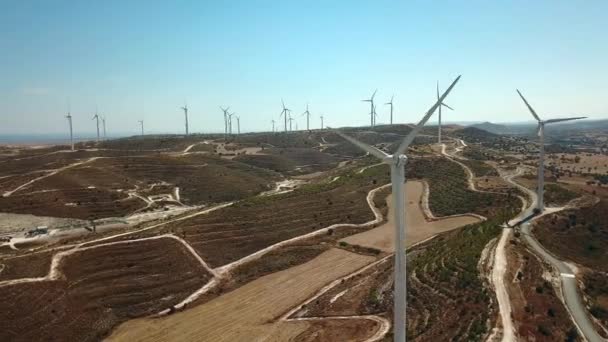 Vista aérea de molinos de viento en las montañas, turbinas eólicas. Primer plano de la turbina eólica sobre el fondo del mar y las montañas Metraje De Stock