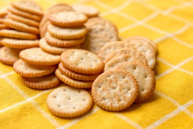 Tuzlu Yuvarlak Kraker. Kraker Yığını. Kazık Sütunu. Kurabiye krakeri. sarı masa örtüsü.
