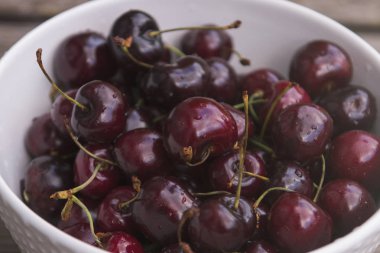 Ahşap arka planda taze kiraz tabağı. Taze kirazlar. Tatlı kirazlar.