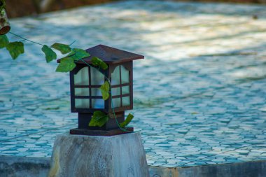 Bahçedeki ahşap fenerin yatay görüntüsü.