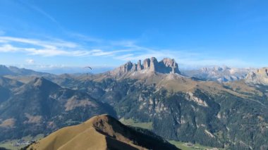 Kuzey İtalya 'daki Dolomitler' in tepelerinden yükselen paraglider açık mavi gökyüzünün altında
