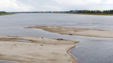 Yakutistan'ın vahşi kuzeyinde ki Vilyu Nehri'nin Kumlu Kıyısı ile diğer tarafta ki ulus Suntar köyünün evleri bulutların altında.
