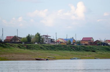 Tekneler Rusya'da Yakutistan'ın kuzeyinde ulus Suntar köyünün evleri ile uçurumda Viluy nehri kıyısında bulunmaktadır.