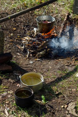 Yakutistan'ın vahşi kuzeyinde ki kamp ateşinde bir kovanın içinde, gölden gelen su kaplarının yanında kaynamak için et parçaları süzülüyor. Yemek istirahatte.