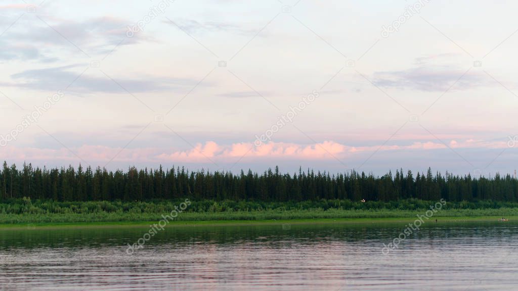 The shore of the wild Northern river Viluy at the beginning of the spruce taiga and silhouettes of people and boats.