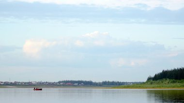 Köy evleri ve ladin Taiga arka planda kıyıya kıyıya sahilden nehir vilyu üzerinde yüzen kürekler ile bir teknede Kuzey YAKUTS insanların üç belirsiz siluetleri.