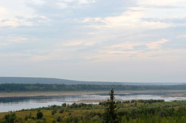 Orman ile büyümüş dağlar ile mavi gökyüzü altında yakut Kuzey Nehri Viluy Bankası yakınında düz yalnız Ladin.