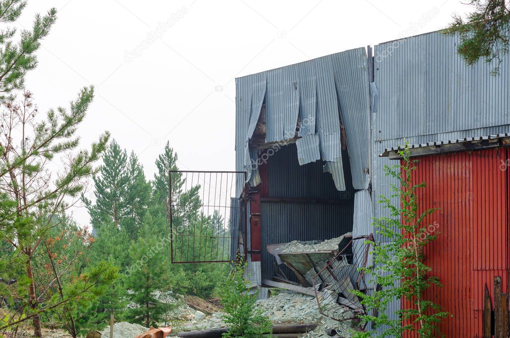 The hole in the metal wall of the hangar of the factory because of the body sticking out of the truck at the factory in Northern Yakutia.
