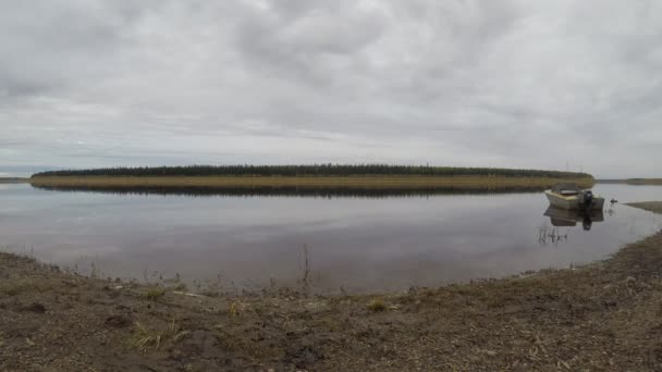 Yakutistan'daki Vilyui ulus Suntar nehri hareketine. Dağların ve iğne yapraklı orman ve bağlı demir Sovyet tekne arka planda kıyıda su akışı ve bulutlu gökyüzü Timelapse. — Stok video