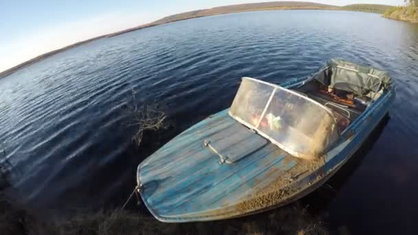 Time lapse mouvement rapide de l'eau et un bateau à moteur en fer attaché à la jetée sur la taïga de la rivière Nord à Yakutia sur un fond de montagnes et de forêts de pins . — Video