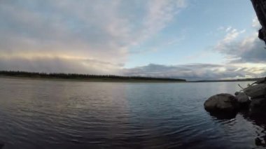 Yakutia akşam gün batımında nehir feribot üzerinde yüzen taiga ormanları ile şerit üzerinde mavi gökyüzü ile bir yönde nehir Vilyuy hareketinin Timelapse.