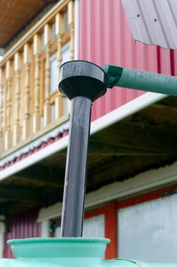 Köyün çatısından gelen su, huniye doğru giden drenaj için oluk içine akar ve varil içine düşer. Yakutistan Kuzey halklarının içme suyu toplamak.