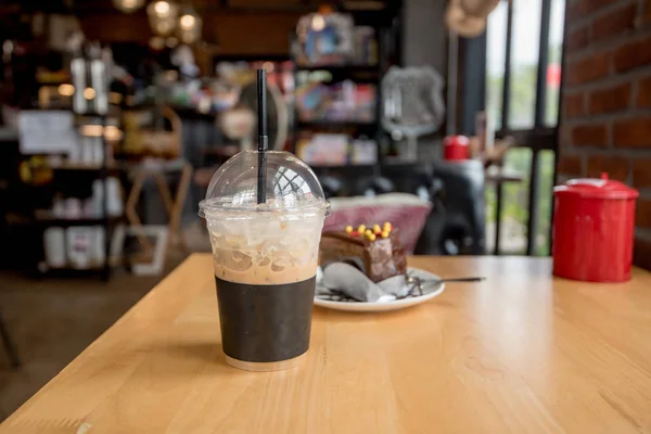 ice coffee take away and cake on wooden background