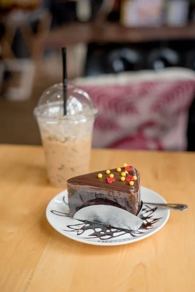 ice coffee take away and cake on wooden background