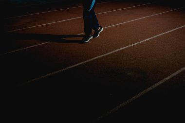 Atletizm insanlar gece kırmızı koşu pistinde çalışan