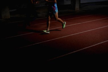 Atletizm insanlar gece kırmızı koşu pistinde çalışan
