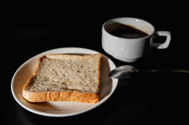 sıcak kahve ve siyah arka plan üzerine kepekli ekmek