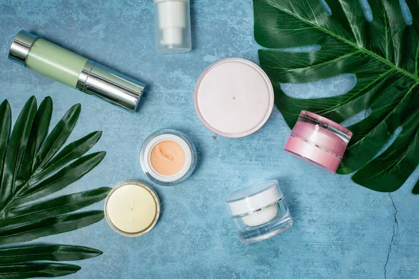 konser arka planda kozmetik ürün ve tropikal yaprakları