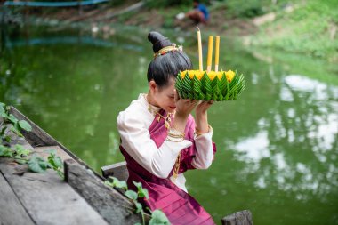 Güzel bir kadın yüzen sepet ya da kratong tutar, Tayland 'da loy kratong festivali