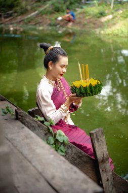 Güzel bir kadın yüzen sepet ya da kratong tutar, Tayland 'da loy kratong festivali