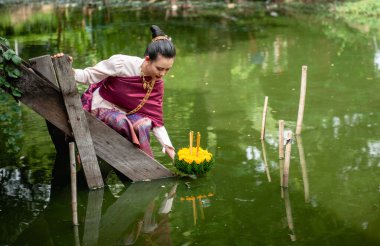 Güzel bir kadın yüzen sepet ya da kratong tutar, Tayland 'da loy kratong festivali