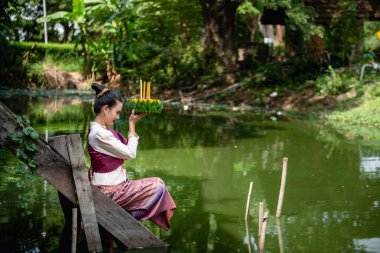 Güzel bir kadın yüzen sepet ya da kratong tutar, Tayland 'da loy kratong festivali