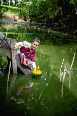 Güzel bir kadın yüzen sepet ya da kratong tutar, Tayland 'da loy kratong festivali