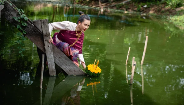 Güzel bir kadın yüzen sepet ya da kratong tutar, Tayland 'da loy kratong festivali