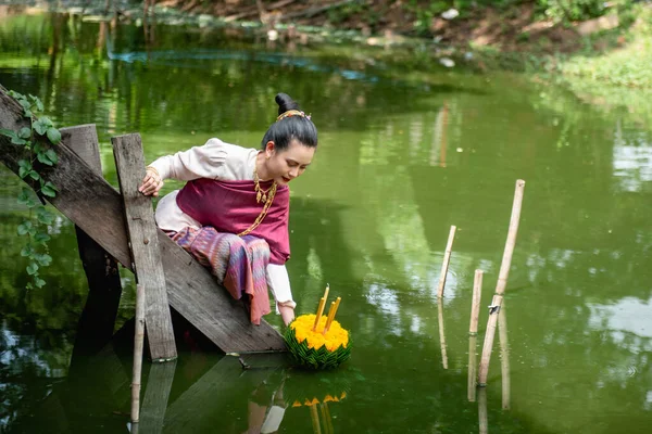 Güzel bir kadın yüzen sepet ya da kratong tutar, Tayland 'da loy kratong festivali