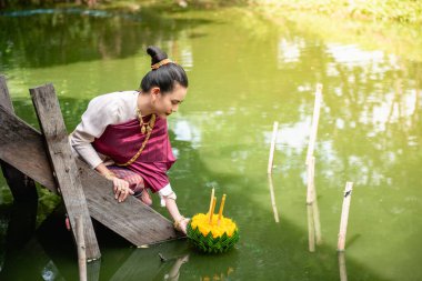 Güzel bir kadın yüzen sepet ya da kratong tutar, Tayland 'da loy kratong festivali