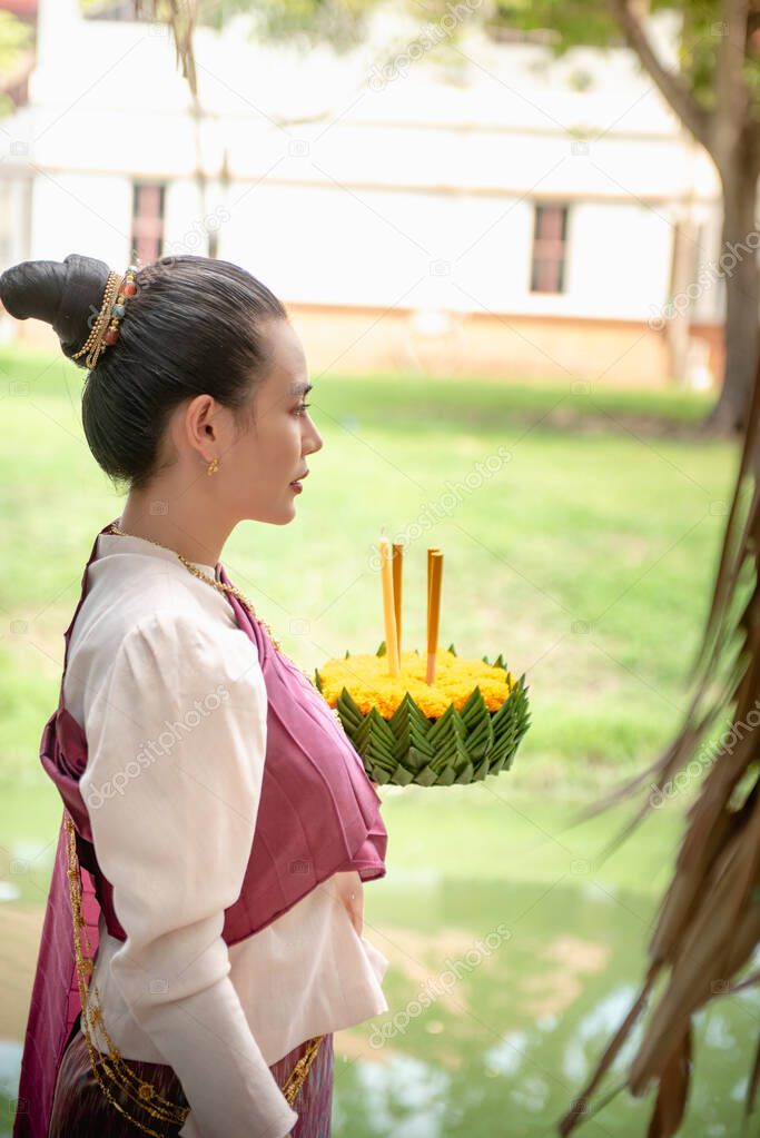 Beautiful woman hold floating basket or kratong, loy kratong festival in Thailand