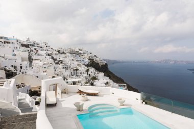 Santorini, Yunanistan - Mayıs 2018: Ege Denizi üzerinden görünüm, Firostefani Köyü ve volkan caldera ön lüks otel ve sonsuzluk yüzme havuzu ile. Santorini Island, Yunanistan.