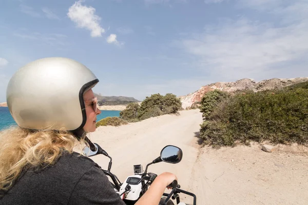 Genç kadın Firiplaka beach, Yunanistan Milos Adası Sahil yolu üzerinde Kiralama quad Bisiklet sürüş