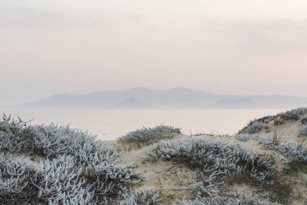 Deniz ve dağlar üzerinde arka planda Milos island, Yunanistan ile kum tepeleri. Gün batımı, ton perspektif alınan atış.