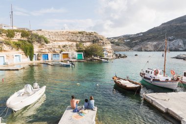 Mandrakia, Yunanistan - Mayıs 2018: köy bakan iskelede oturan aile