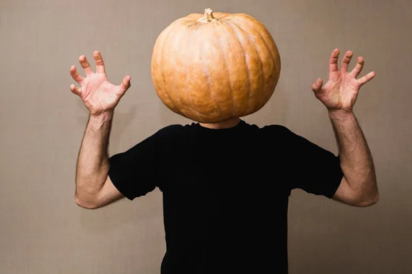 Hombre joven en camiseta negra con una calabaza grande en lugar de su cara —  Fotos de Stock