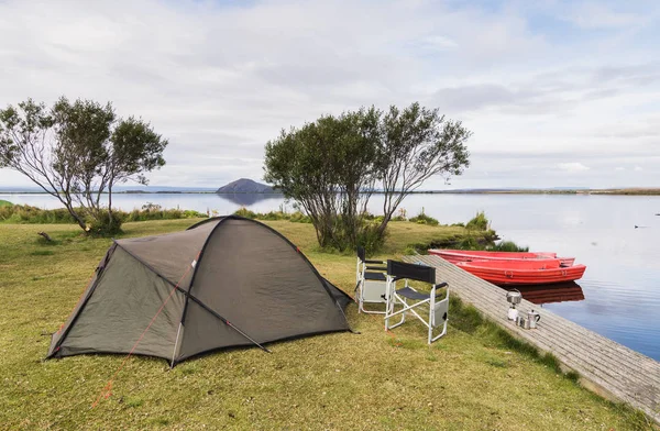 Bir çadır, iki katlanır sandalye ve tekneler Myvatn kıyı Gölü, İzlanda ile kamp sitesi.