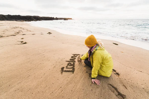Meisje Gele Regenjas Schrijven Van Het Woord Ijsland Het Zand — Stockfoto