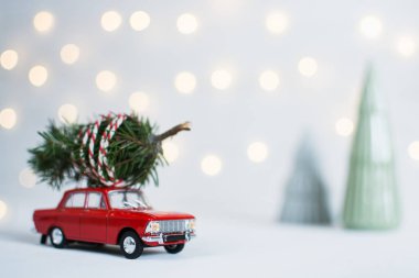 Red toy car with a christmas tree on the roof clipart