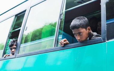 Katmandu, Nepal - Nisan 2015: genç üzgün çocuk otobüs pencereden dışarı bakıyor.