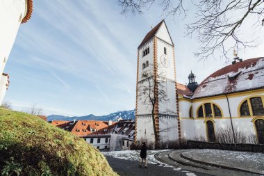 Fussen, Almanya - Aralık 2018: Hohes kale yakın Basilika St. Mang yanında yürüyen adam