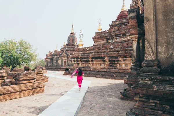 Femme en robe rouge court à côté du temple bouddhiste de Bagan, Myanmar — Photo