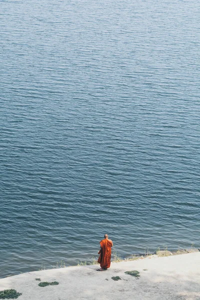 Бірманський буддійський чернець в помаранчевому халаті стоячи на берегах річки Ірравадді в Баган, М'янма — стокове фото