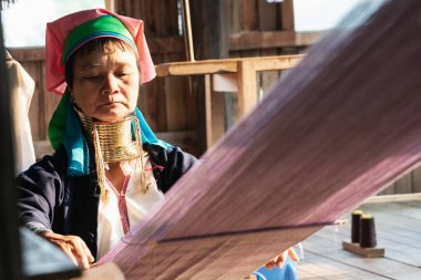Inle, Myanmar - Mart 2019: Kayan Lahwi kabilesi uzun boyunlu kadın tezgaharkasında oturuyor