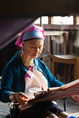 Inle, Myanmar - Mart 2019: Kayan Lahwi kabilesi uzun boyunlu kadın tezgaharkasında oturuyor