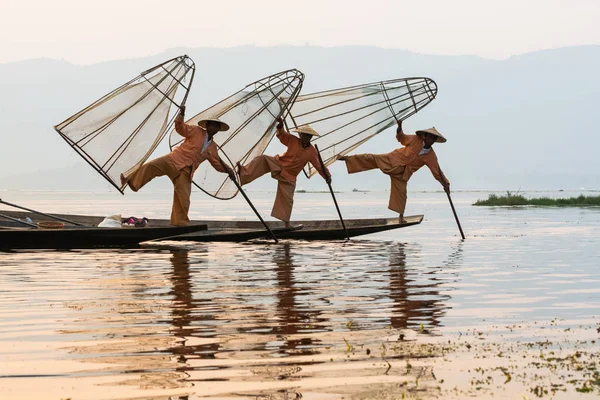 Inle, Myanmar - marzo 2019: tre tradizionali pescatori birmani di zampe a remi al lago Inle — Foto Stock