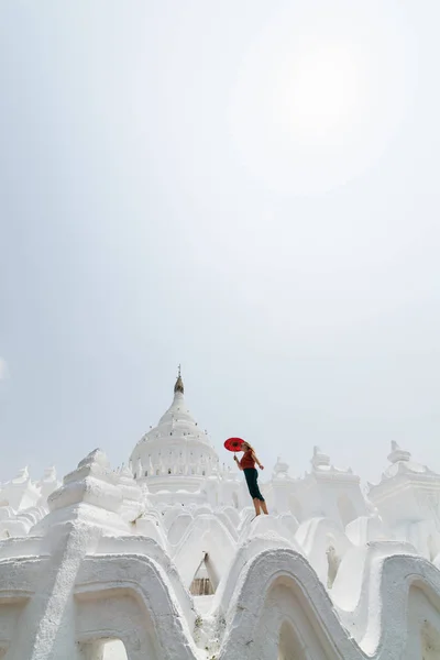 Блондинка кавказька жінка з червоним парасолькою ходьба на стінах Мисостіан пагода в Мандалай, М'янма — стокове фото
