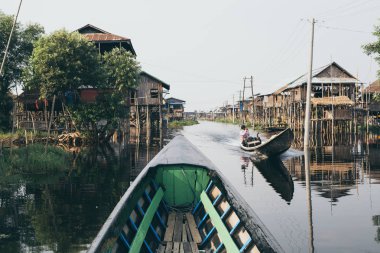 Nampan, Myanmar - Nisan 2019: Inle gölündeki Nampan köyünden geçen geleneksel Birmanya ahşap teknesi