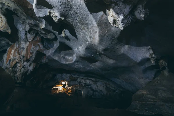 Menschliche Silhouette steht in der Höhle mit Licht, das von der Decke kommt — Stockfoto